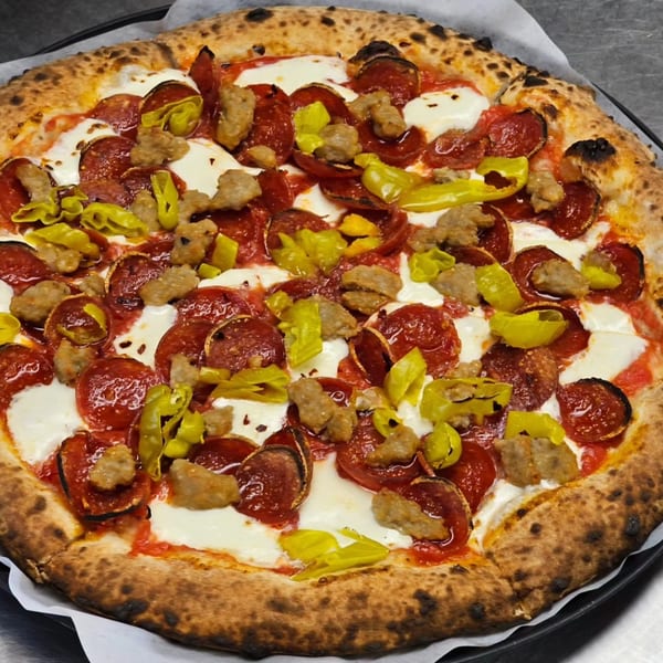 Pizzaluté pizza with pepperoni, sausage, and banana peppers on a crispy crust.